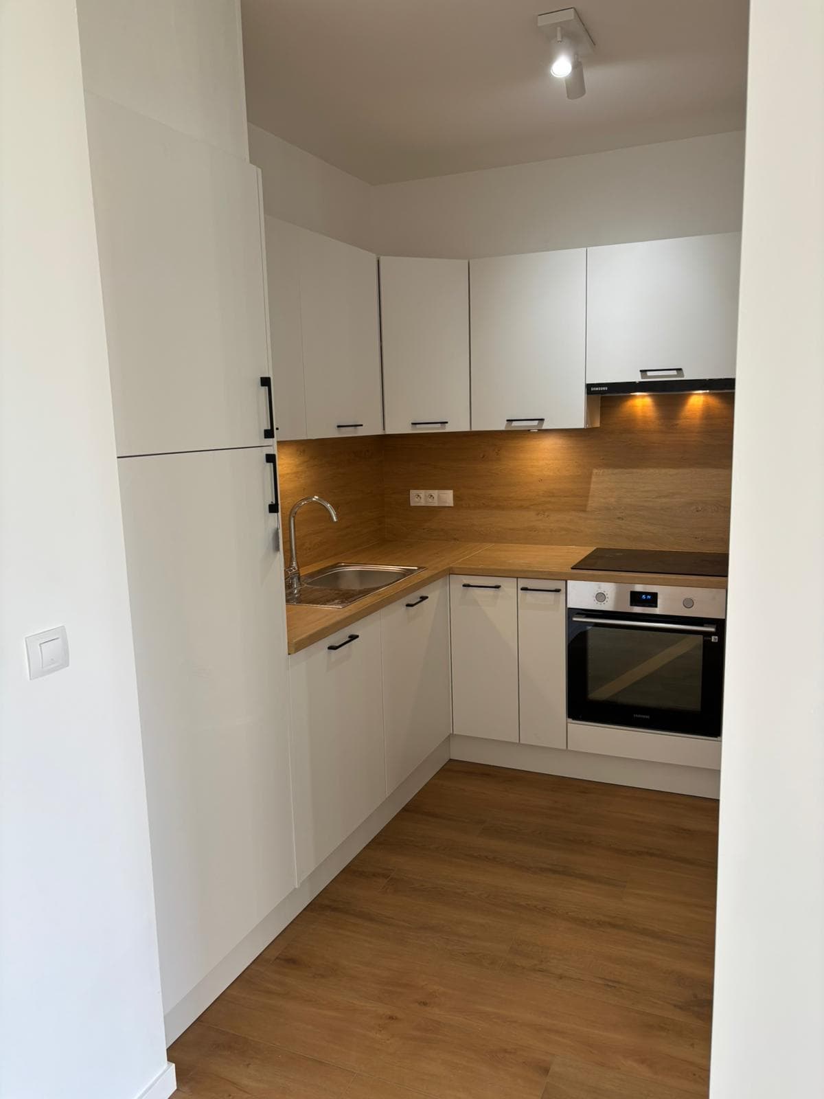Cuisine blanche rénovée avec crédence bois et four encastré, Anderlecht