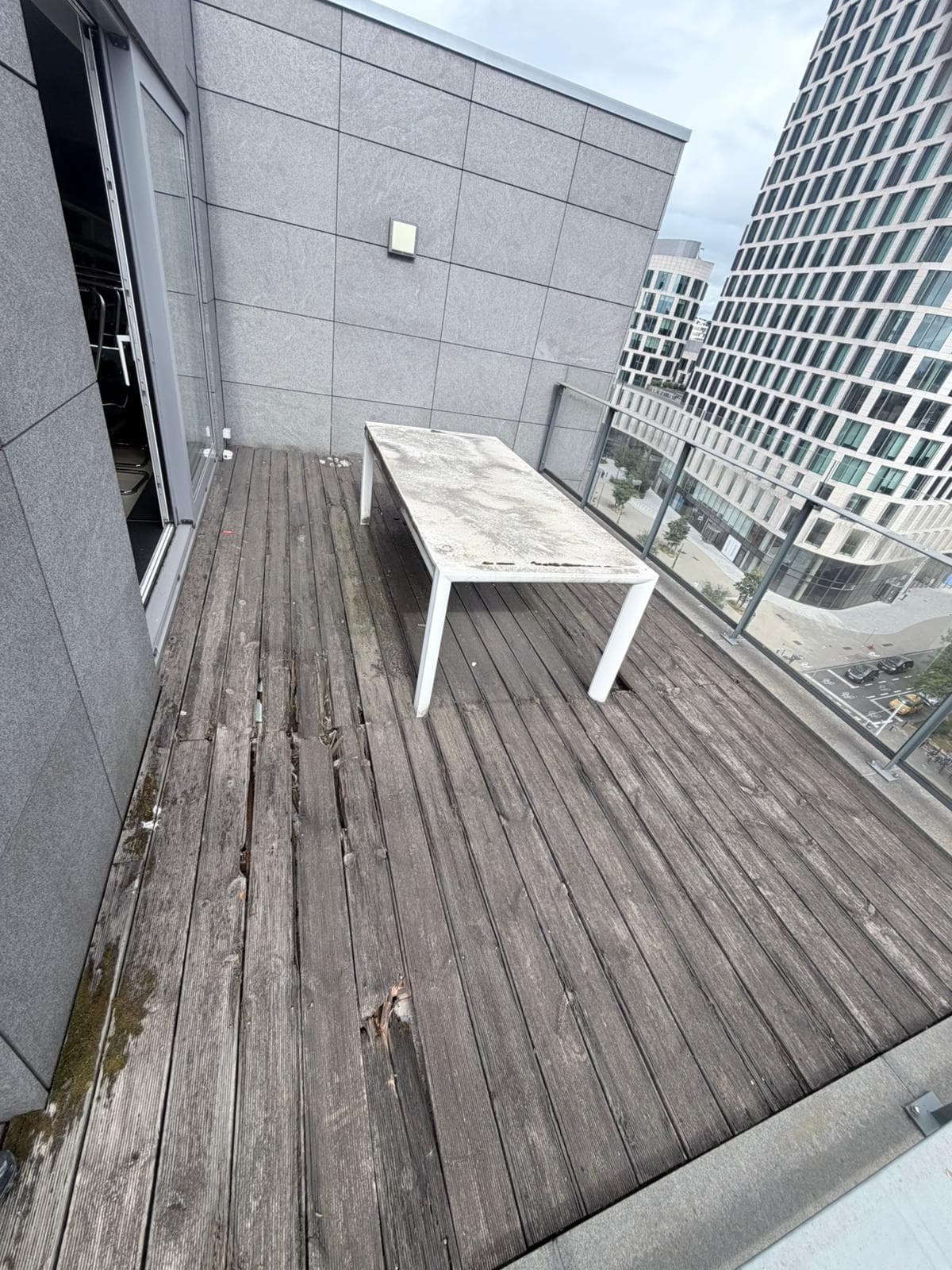 Terrasse en toiture avant rénovation, lames de bois fendues, Bruxelles